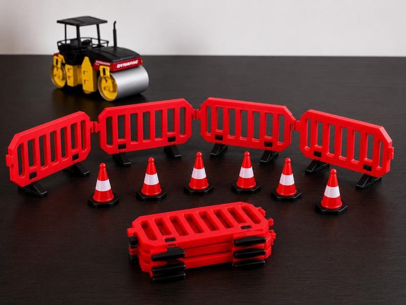 Miniature UK Traffic Cones & Roadwork Barriers Set May include: A toy construction set featuring a black and yellow road roller, six red and white traffic cones, and several red plastic interlocking safety barriers arranged in a semi-circle with a stack of additional barriers in the foreground.