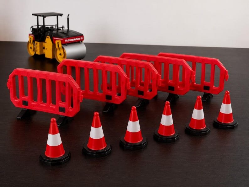 Miniature UK Traffic Cones & Roadwork Barriers Set May include: A miniature yellow and black road roller toy with the text DYNAPAC, four red plastic interlocking construction barriers, and six red and white traffic cones arranged in a row on a dark surface.