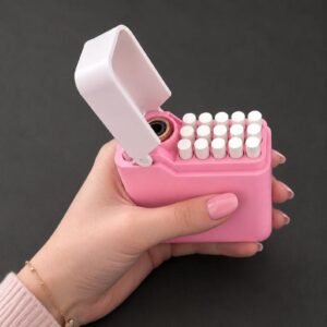 May include: A pink rectangular cigarette case with a white hinged lid that is open. The case contains a grid of white cigarette filters arranged in rows. The exterior of the case is a solid matte pink colour, and the interior mechanism is white.