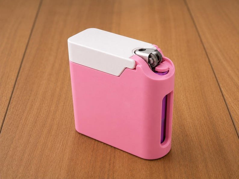 Pink Cigarette Case with Lighter Holder — King Size, 15 Cigarettes May include: A rectangular pink lighter case with a white top cover and a metallic ignition wheel mechanism. The case features a vertical cutout on the side, revealing a purple lighter body inside the protective pink shell.