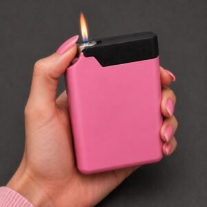 May include: A rectangular pocket lighter with a matte pink body and a black top section. The lighter features a metallic ignition point emitting a small, visible orange and blue flame. The design is compact with rounded corners and a smooth finish.