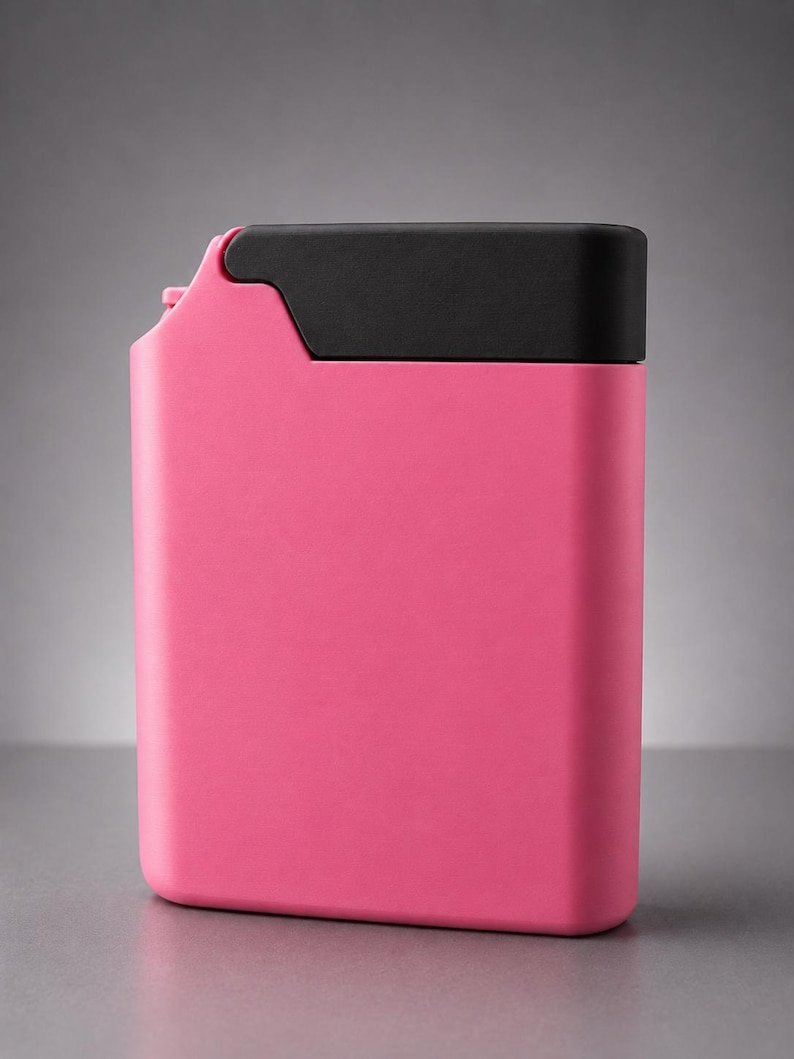 Pink Cigarette Case with Built-In Lighter Holder May include: A rectangular, flat-sided container featuring a vibrant pink body and a solid black cap that covers the top portion. The object has a smooth, matte finish with rounded corners and a small, protruding spout detail on the upper left side.