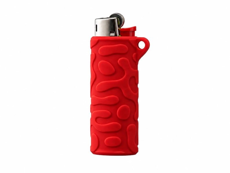 BIC Lighter Keychain Sleeve May include: A red lighter encased in a silicone sleeve featuring a raised, organic, amoeba-like pattern. The lighter has a metallic silver ignition top and a small circular loop integrated into the upper right side of the textured red cover.